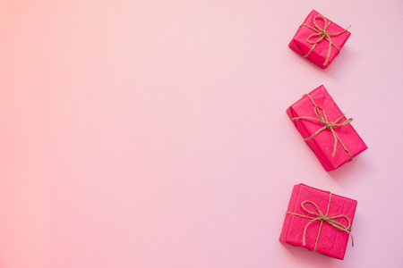 Red gift box on pink gradient background. February 14 card, Valentine's day. 8 March, International Happy Women's Day. Flat lay, top view, copy space.の写真素材