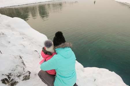 Lake with ice reflecting snow covered mountains. Blue Lake in the Altai Mountains.の写真素材