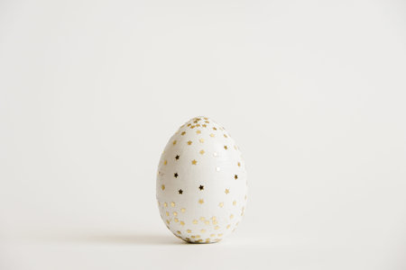 Easter white egg with glitter stars  isolated on white background. Minimal easter concept. Happy...