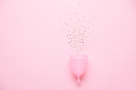 Menstrual cup on pink background. Alternative feminine hygiene product during the period. Women health concept.の写真素材