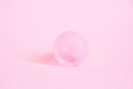 Menstrual cup on pink background. Alternative feminine hygiene product during the period. Women health concept.の写真素材
