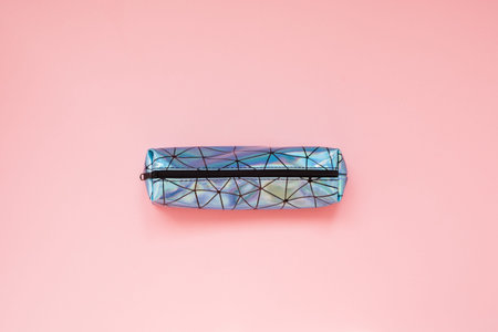 Back to school. Pencil case with school supplies on pink table.
