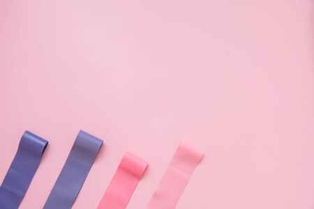 Fitness elastic band on pink background. Colorful expander gums. Sport trend conceptの写真素材