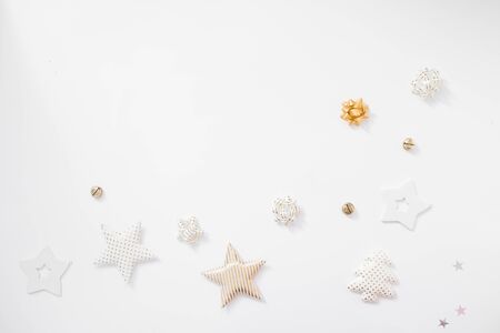 Christmas background. Golden stars, bells and bows on white background. Flat lay, top view, copy spaceの写真素材