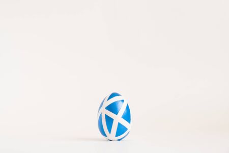 Easter golden decorated egg with geometric pattern isolated on white background. Minimal easter concept. Happy Easter card with copy space for text Top view, flatlay.の写真素材