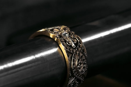  Close-up of hand of a goldsmith setting a precious stone with diamonds Ring repairing. Putting the...