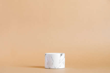 Empty white marble podium on pastel beige color background. Minimal boxes and geometric podium. Scene with geometrical forms. Empty showcase for cosmetic product presentation. Fashion magazine.の写真素材