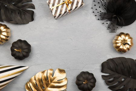 Modern Halloween background with gold ans black pumpkins, monstera, stars confetti. Halloween party...
