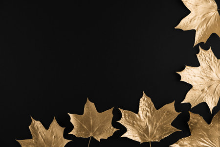 Autumn composition. Frame made of autumn golden maple leaves on black background. Flat lay, top...