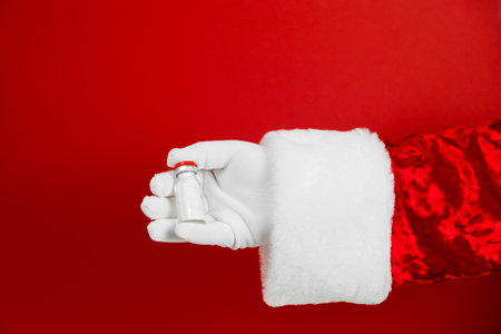Santa hand with syringe, medical injection. Medicine equipment with needle. Liquid drug or drug. Hospital medical care. Corona virus vaccine, covid -19 vaccination.の写真素材