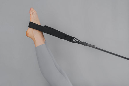 A detailed closeup of a foot work and core exercise on a Balanced Body Reformer machine illuminated...