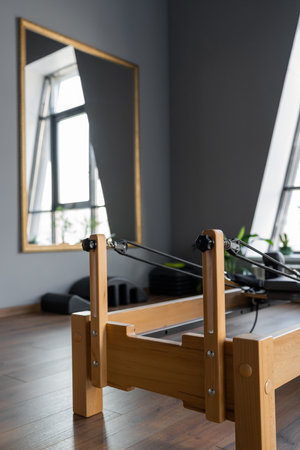 Pilates equipment. Reformer bed. Reformer pilates studio machine for fitness workouts in gym. Fit, healthy and strong authentic body. Fitness concept.の写真素材
