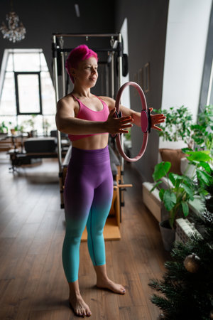 A woman is using a hip circle at Pilates workout in studio, being active and committed to exercisingの写真素材