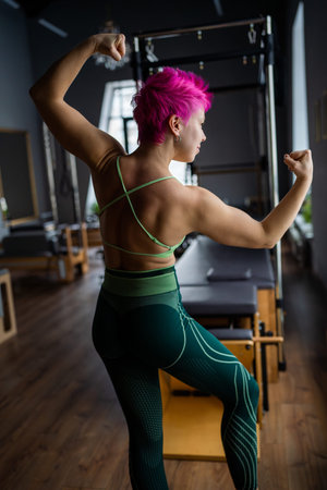 Pilates fitness trainer beautiful back relief. Pilates studio. Young sporty attractive woman wearing...