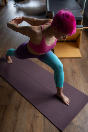 A Yoga Pose featuring Colorful Leggings and Vibrant Pink Hair for a Stylish Workoutの写真素材