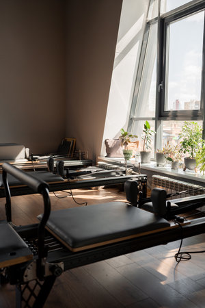 Modern Pilates studio with reformer beds bright, spacious windows for exercise and wellbeingの写真素材