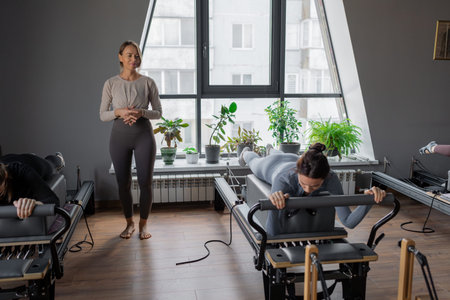 Woman training pilates on the reformer bed. Reformer pilates studio machine for fitness workouts in gym. Fit, healthy and strong authentical body. Fitness conceptの写真素材