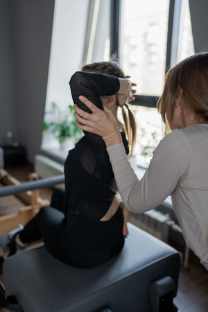 Woman doing rotation exercise on Pilates Reformer for the chest and back muscles, focusing on flexibility, strength, and control with determinationの写真素材