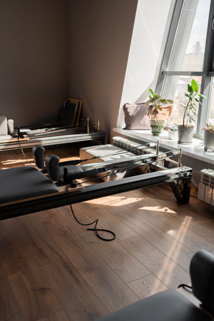 Modern Pilates studio with reformer beds bright, spacious windows for exercise and wellbeingの写真素材
