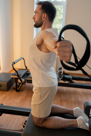 Kneeling pulley exercise, practicing on reformer pulley row focusing on shoulder controlの写真素材