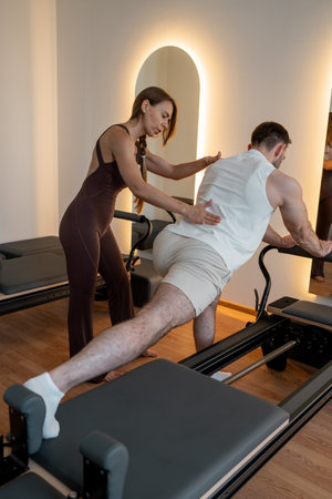 Instructor guides posture correction, Calm atmosphere with handson guidance for posture improvementの写真素材