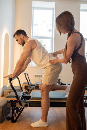 Instructor guides posture correction, Calm atmosphere with handson guidance for posture improvement