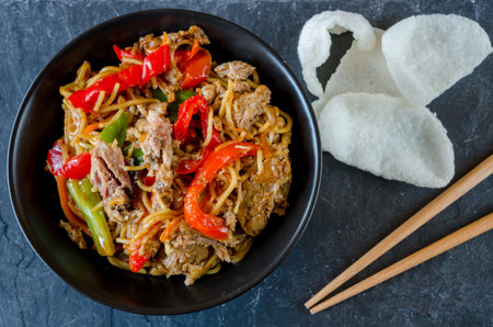 Stir fry noodles with duck and vegetables in a bowl on the tableの写真素材