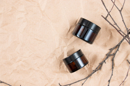 Cometic bottles made of amber glass on crumpled craft paper. Skin care product packaging design. spa concept.の写真素材