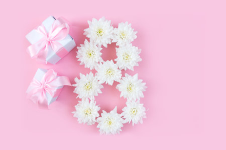 White flowers on a pink pastel background. Festive floral concept with clean text space. flat lay....