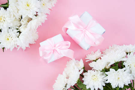 White flowers on a pink pastel background. Festive floral concept with clean text space. flat lay. view from above.の写真素材
