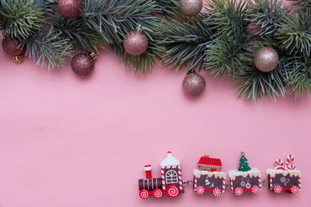 Christmas tree branch decorated with Christmas balls and a toy train. New Year card, top view, flat lay.の写真素材