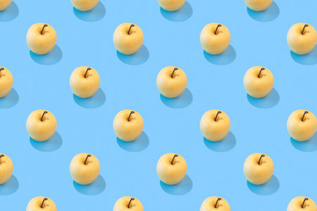 Seamless regular pattern with fresh apples on a yellow background. hard light. Minimal summer...