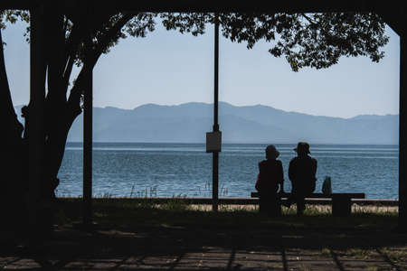 Old people seeing lake lovely in afternoon with silhouetteの写真素材