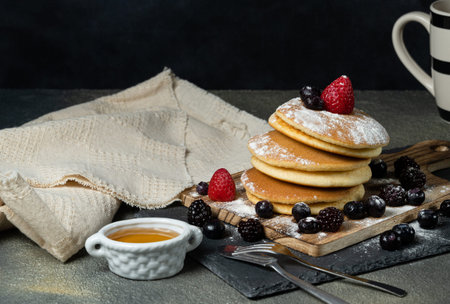 homemade japan sweet pancake dressed with strawberries,berries,sugar and dark background.
