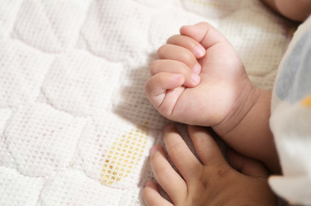 cute baby sleeping on bed with hand close-up shotの写真素材