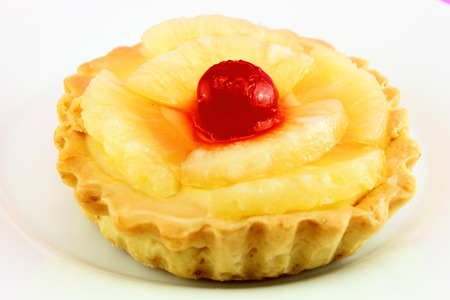 Delicious tart pineapple and cherries. Isolated on white background.の写真素材