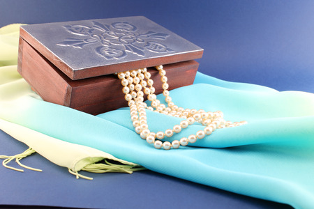 Wooden jewelry box with ornate silver lid and pearl necklace.の写真素材