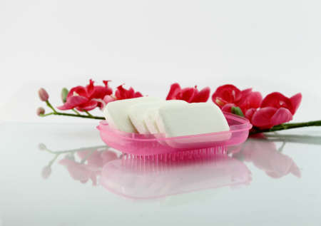 Soaps and pink flowers isolated on white background.の写真素材