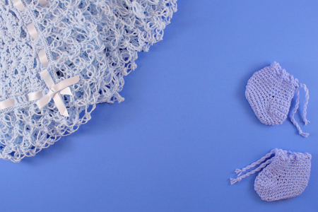 Baby blanket on light blue background with a baby shoes. Baby shower concept in flat layの写真素材