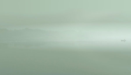 Fog on the morning lake while fishing by boat.の写真素材