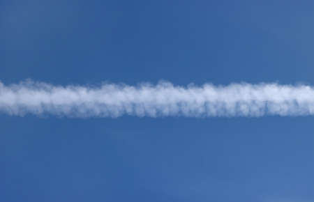 The trail from the flight of the plane in the blue sky.の写真素材