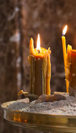 Wax candle burning in a religious church.の写真素材