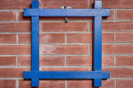 Blue wood frame hung on an exposed brick wall with empty space for text