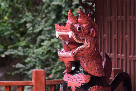 Statue of a lion at the entrance to a Buddhist temple.の写真素材