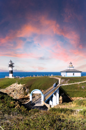 Vertical view of the island of Pancha with its access bridge and lighthouse at sunset with a reddish sky. Spain.の写真素材