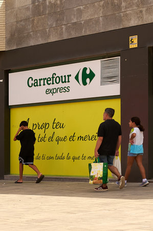 Viladecans, Spain - September 13, 2023: Carrefour Express promotional outdoor sign with people passing in front of it.のeditorial素材