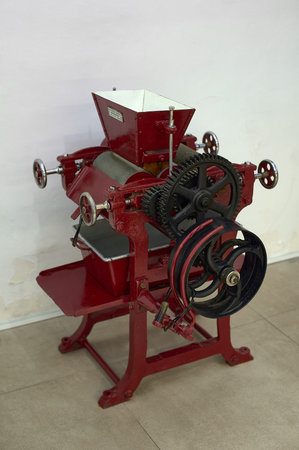 Close-up of an antique machine used in the chocolate making process, showing worn gears and...