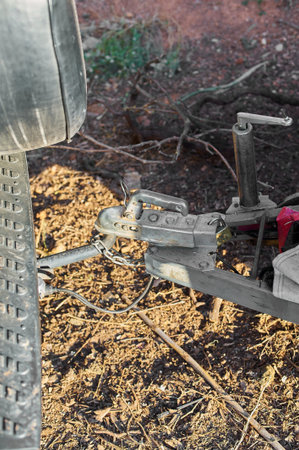 Secure metal hitch with chain and red strap in an outdoor environment, ideal for safe towing.