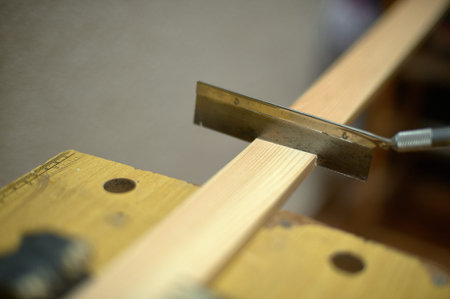 Close-up image of a saw cutting through a piece of wood in a workshop capturing the essence of...