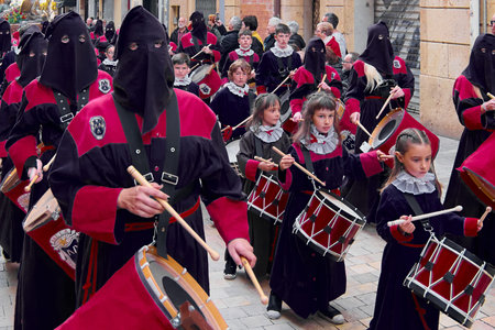 Tarragona, Spain - April 26, 2024: A group of drummers in traditional attire participating in a Holy...
